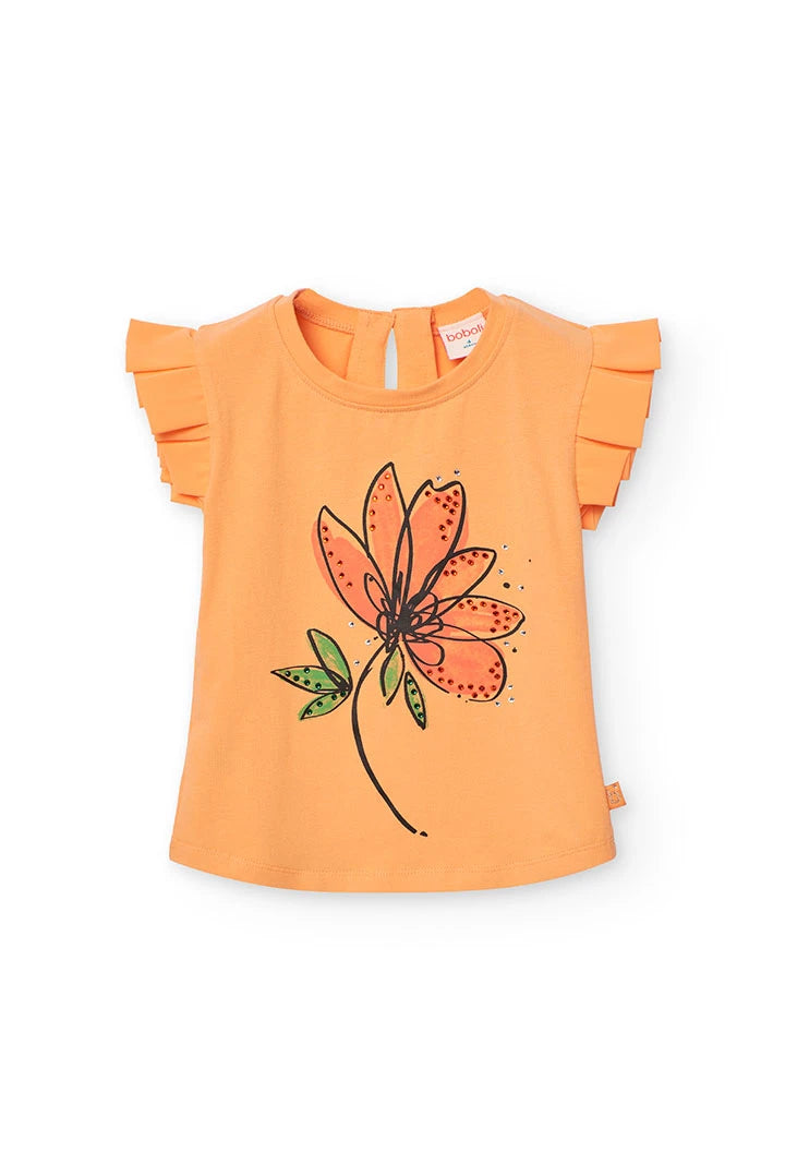 Vista frontal de blusa naranja Boboli con ilustración de flor y aplicaciones brillantes.