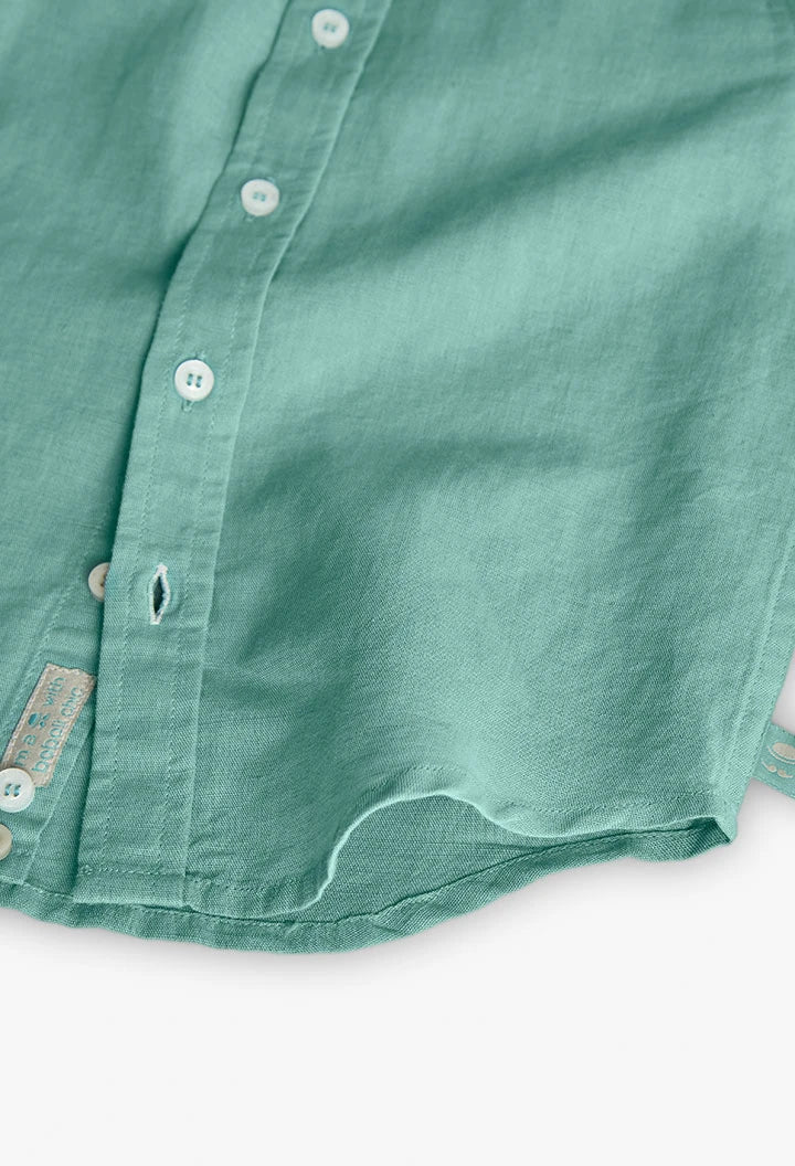 Detalle de la parte inferior de la camisa de lino verde de Boboli, resaltando su tela transpirable y etiqueta de calidad. Prenda versátil para ocasiones especiales.