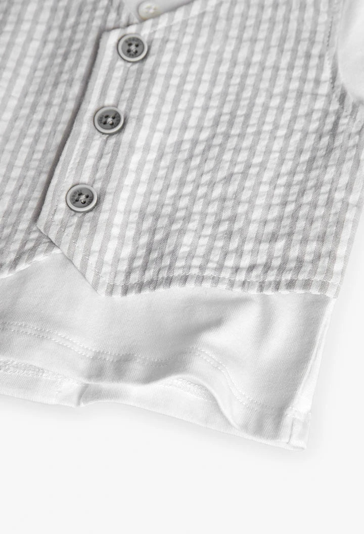 Detalle del chaleco de rayas gris sobre camiseta blanca, mostrando textura y botones.