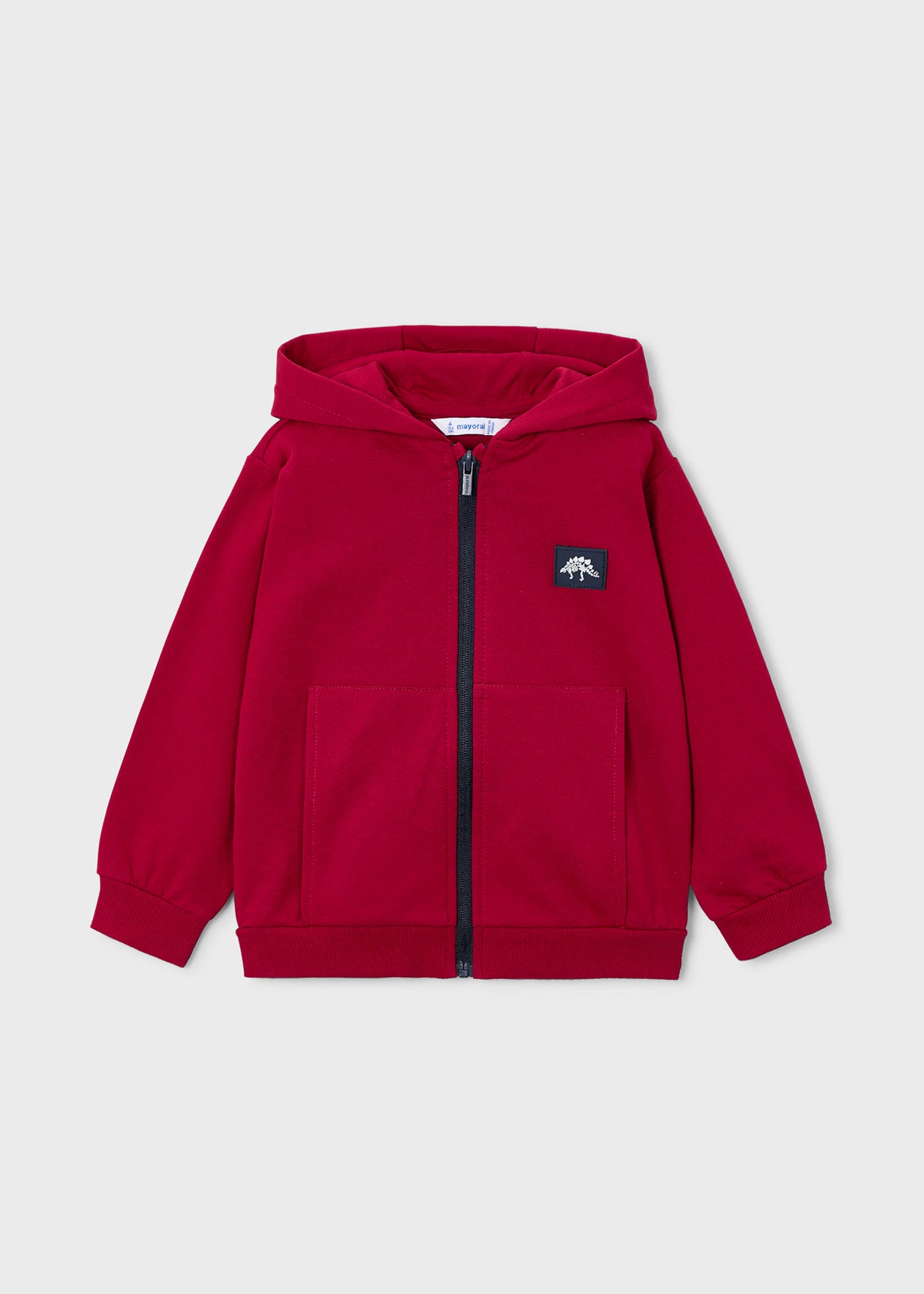Vista frontal de una sudadera roja con capucha, cremallera y un parche de dinosaurio en el pecho, marca Mayoral.