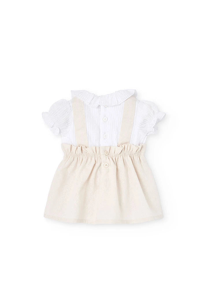 Vista trasera del conjunto para bebé con vestido de lino beige y blusa blanca con botones.