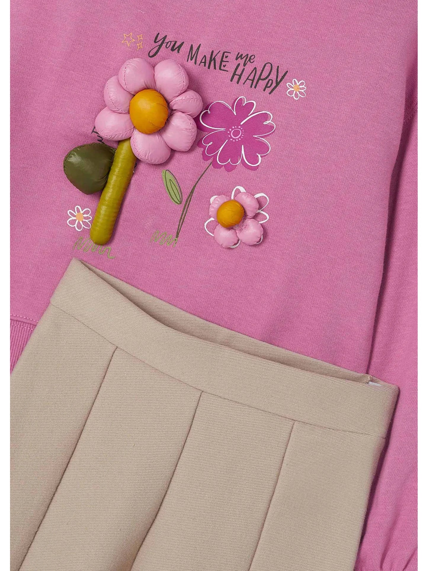 Detalle de flores en relieve de la sudadera rosa Mayoral con pantalón beige plisado de niña