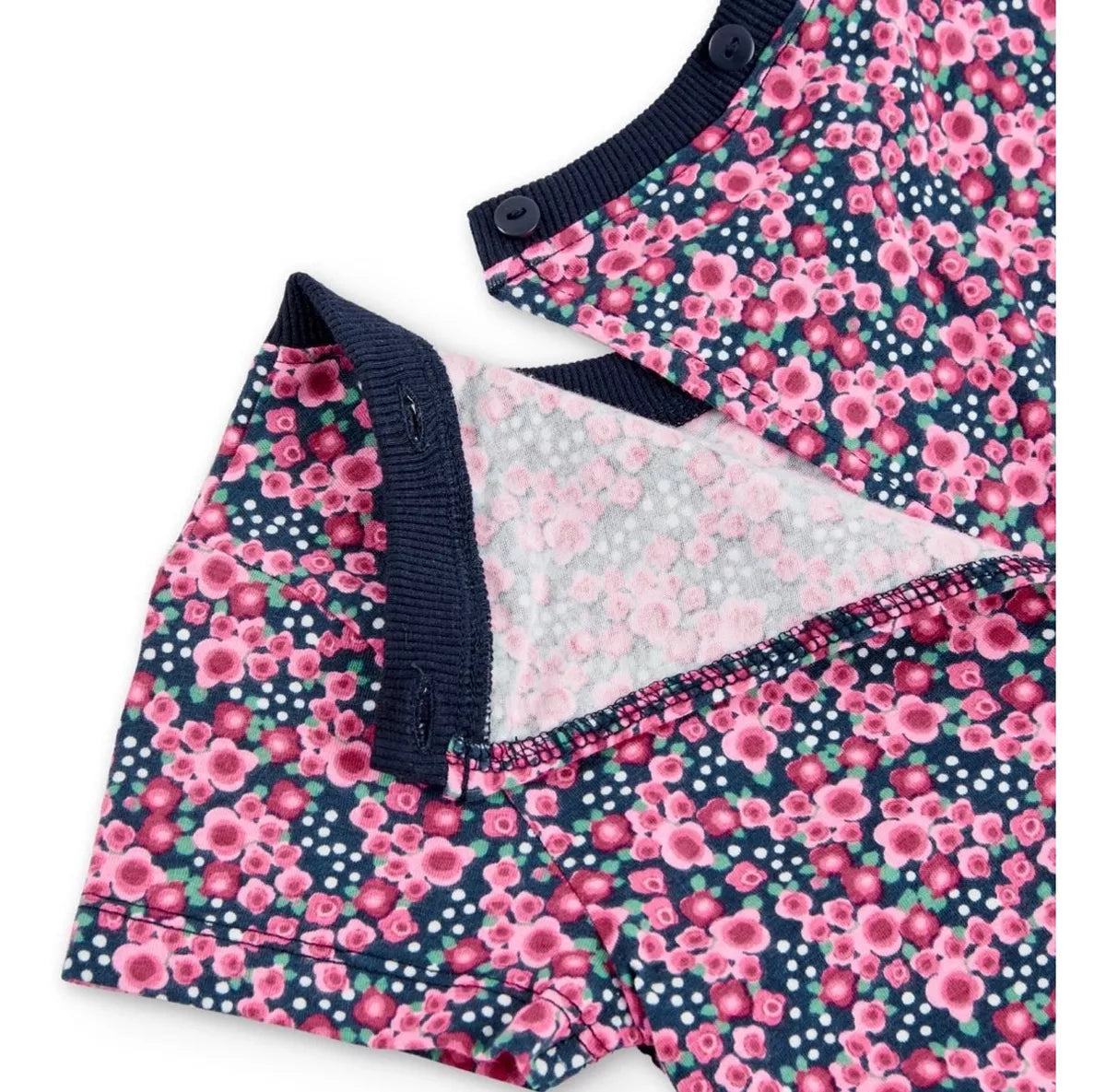 Detalle del cierre de botones en la espalda del jumpsuit corto de Boboli con estampado floral en tonos rosas sobre fondo azul marino. Se muestra la abertura trasera y el ribete elástico en azul marino.