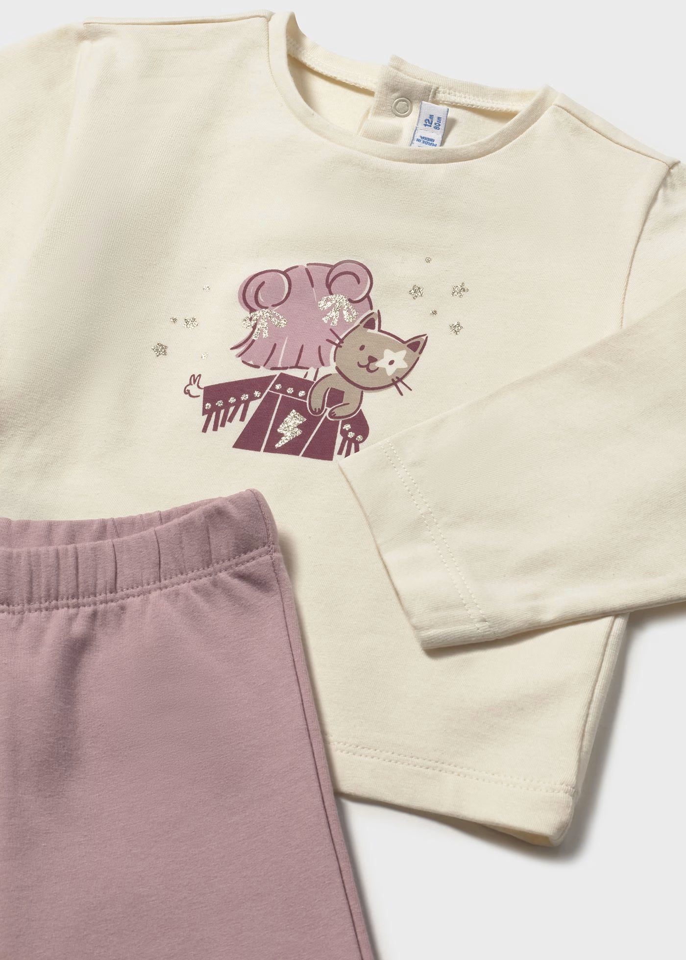 Detalle de una playera para niña con el estampado de una ratita con glitter, junto a un pantalón rosa, marca Mayoral.
