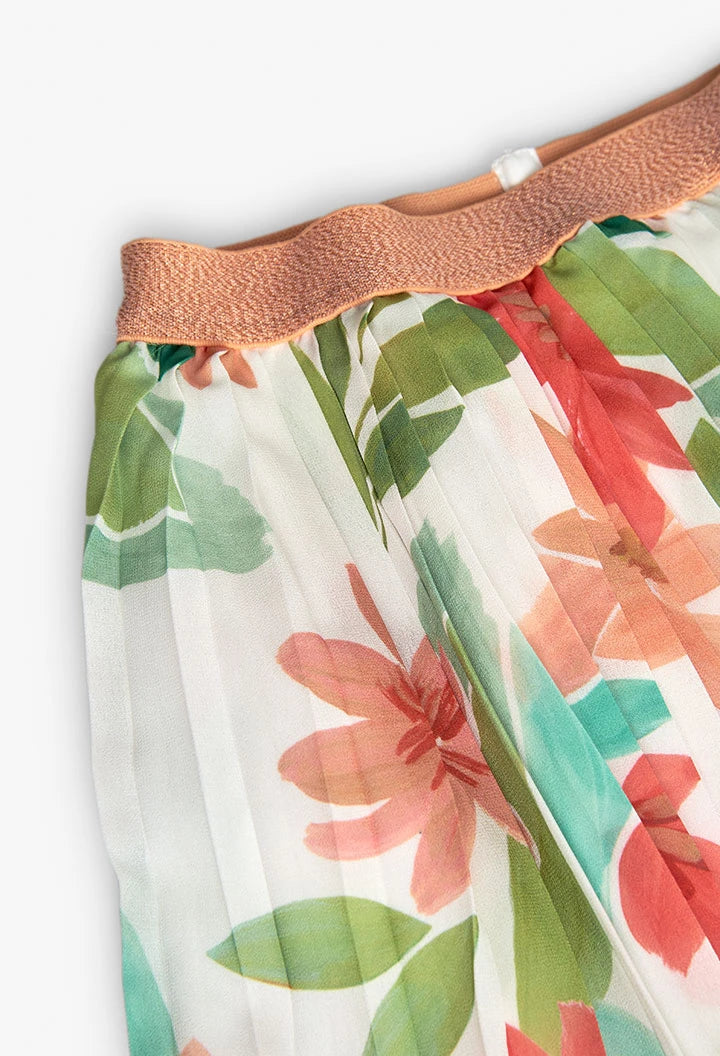 Detalle de cintura elástica en falda de gasa plisada con flores multicolor.