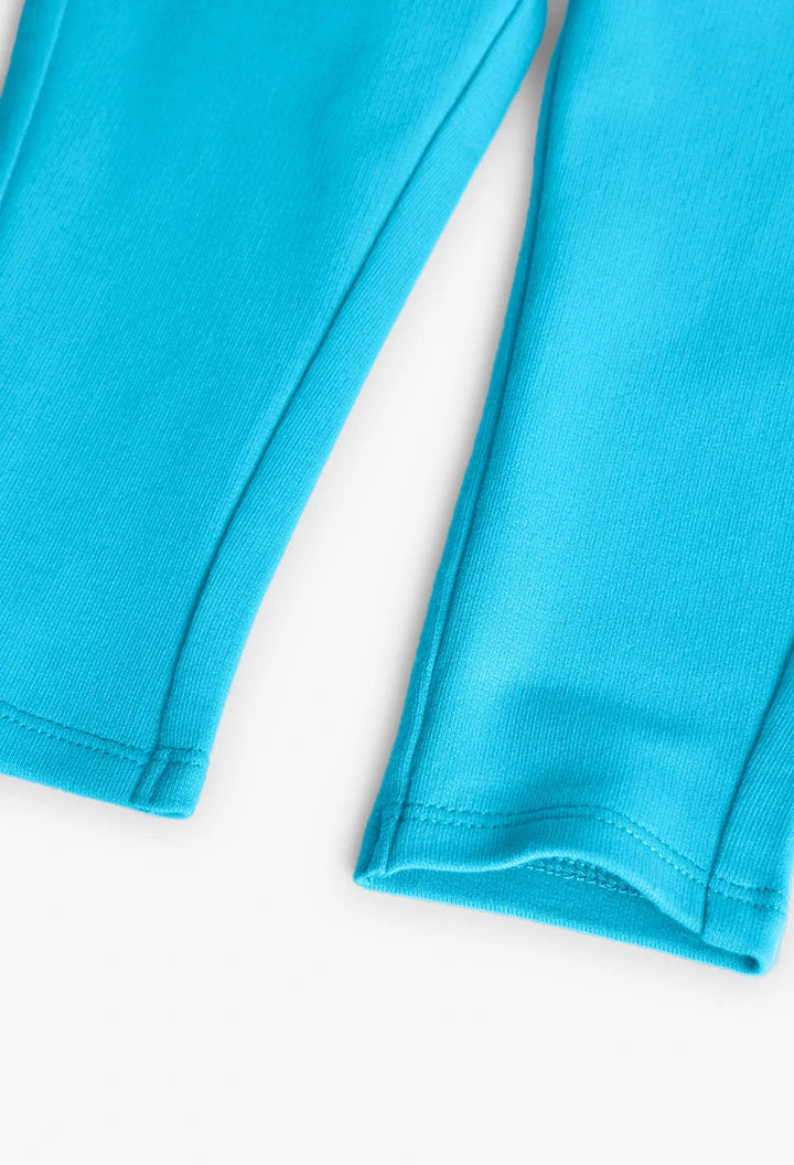 Detalle del dobladillo inferior de los leggings azul turquesa con costura visible
