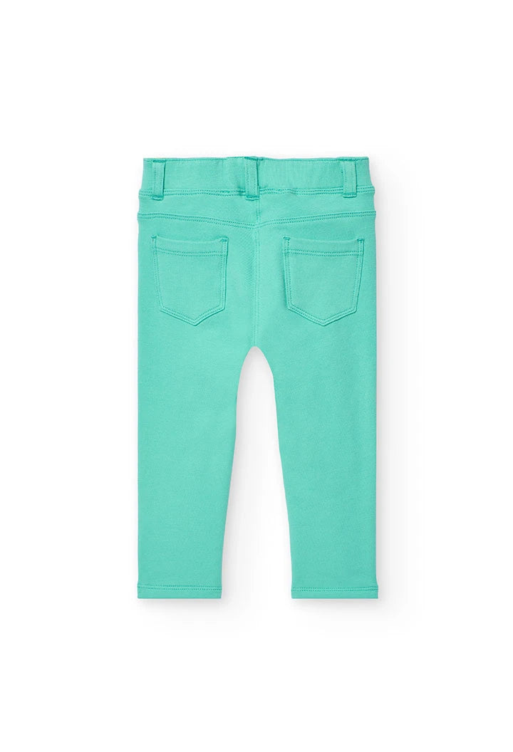 Leggings para niña color verde menta vistos desde atrás, con detalles de costura y bolsillos.