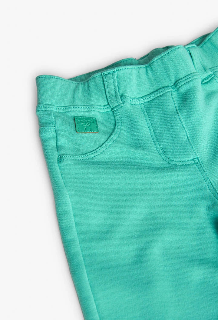 Primer plano del logo de Boboli en la parte delantera del leggings verde, con detalle de costuras y cinturilla.
