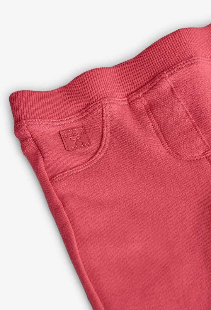 Detalle del bolsillo frontal falso y la placa de la marca en unos jeggings de felpa color coral, marca Boboli.