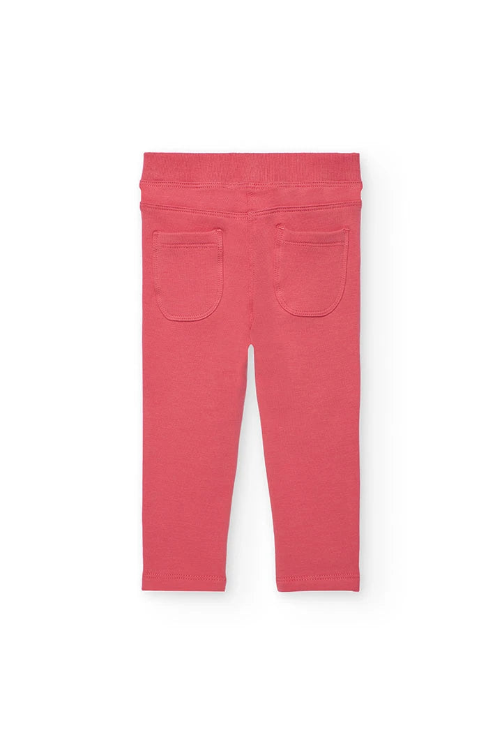 Vista trasera de los jeggings de felpa color coral, mostrando los bolsillos de parche.