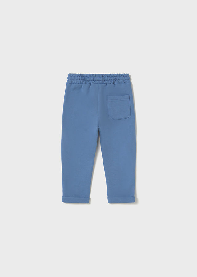 Vista trasera de un pantalón jogger azul para bebé con cintura elástica y un pequeño bolsillo en la parte posterior, diseñado para brindar comodidad y libertad de movimiento.