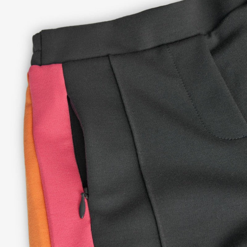 Detalle del pantalón infantil de Boboli en color negro con franjas laterales en tonos vibrantes y bolsillo con cremallera, ideal para un look moderno y funcional.