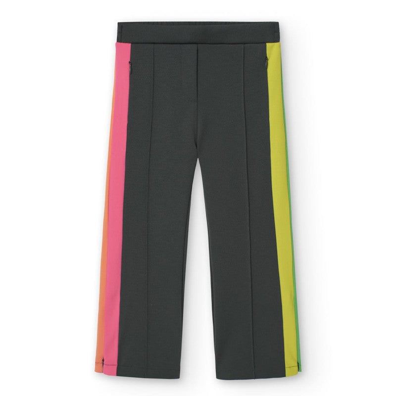 Pantalón infantil de Boboli en color negro con franjas laterales en tonos vibrantes como rosa, amarillo y verde. Diseño moderno y cómodo para niñas con detalles de costura y cierres en los bolsillos.