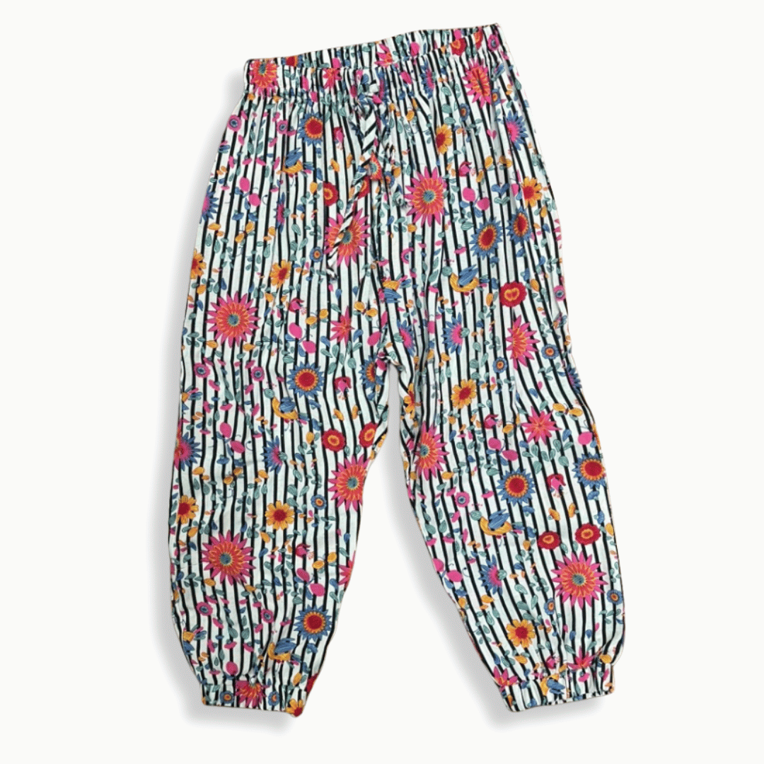 Pantalón infantil con estampado vibrante de flores y rayas, confeccionado en tela ligera con cintura elástica y resorte en los tobillos para mayor comodidad.