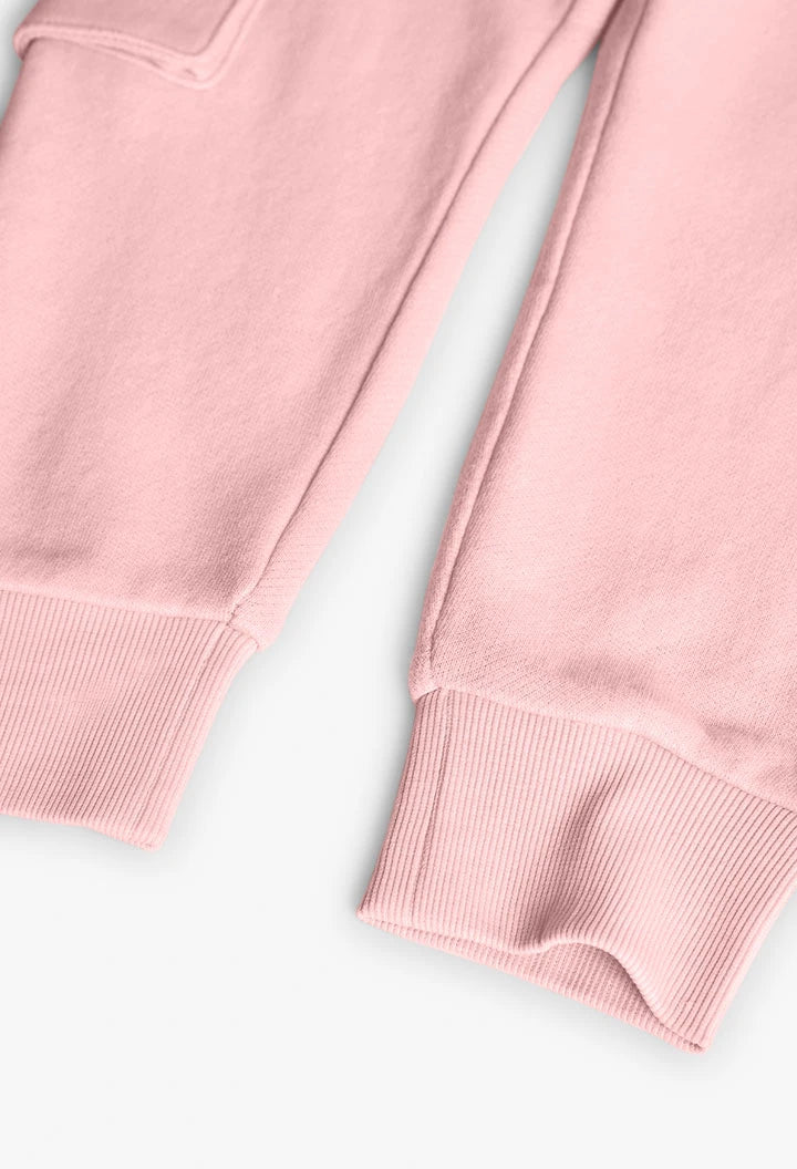 Detalle inferior de pants rosas de niña con puños elásticos acanalados.