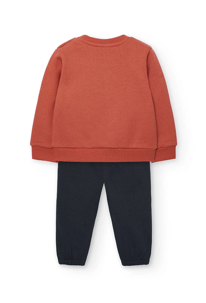 Vista trasera del conjunto de sudadera teja y pantalón jogger oscuro para niña.