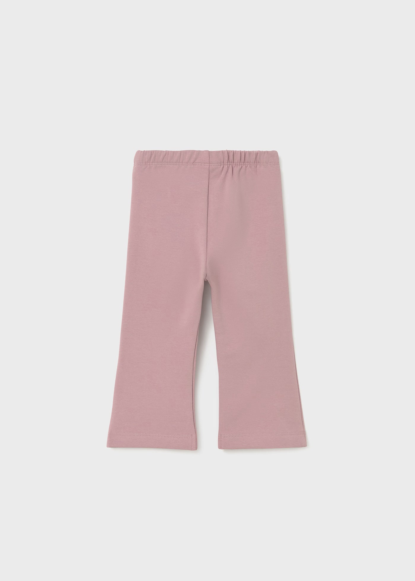 Vista frontal de un pantalón de licra color rosa malva para niña con corte acampanado y cintura elástica.
