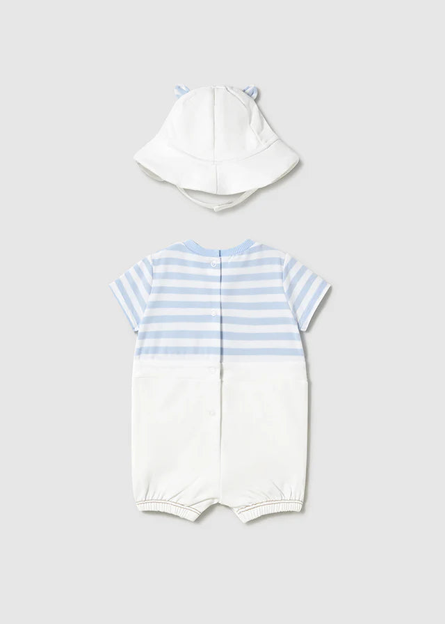 Vista trasera del conjunto para bebé compuesto por un enterizo de manga corta con diseño de rayas azules y blancas, cierre de broches en la parte posterior y elástico en las piernas para mayor comodidad. Incluye un gorro blanco con orejitas, ideal para proteger del sol y completar un look tierno y funcional.