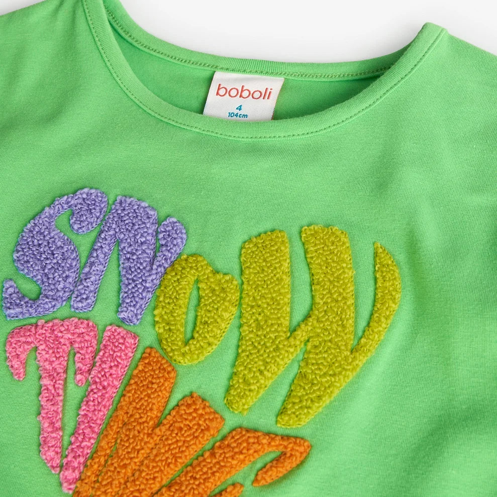 Detalle de la sudadera verde infantil Boboli con bordado en relieve “Snow Time” en colores vibrantes. Tela de algodón suave y cómoda para niñas.