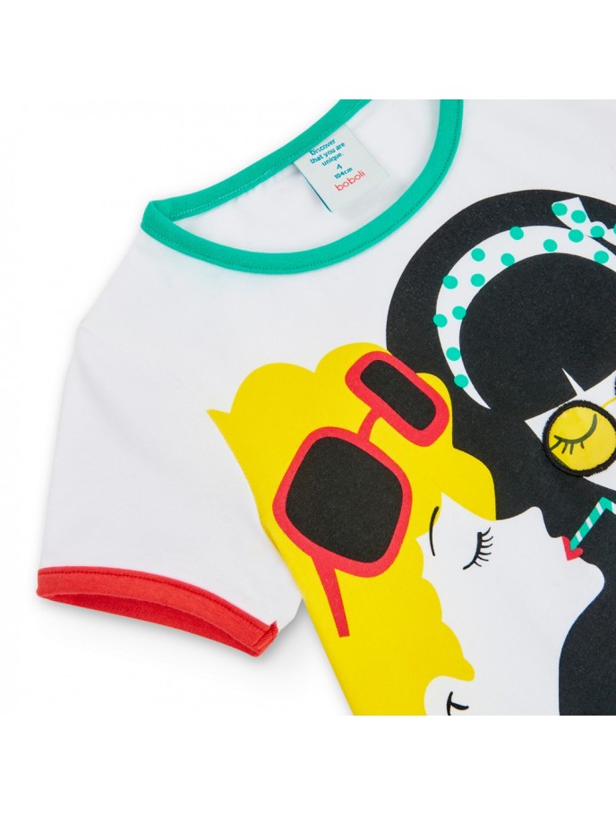 Detalle del estampado en una playera blanca de Boboli con ilustración de rostros femeninos, colores vibrantes y detalles en mangas y cuello.