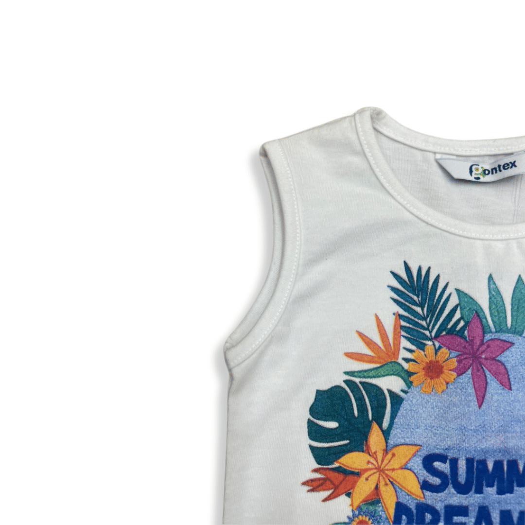 Detalle de la parte superior de una blusa infantil sin mangas en color blanco, con estampado tropical y texto “Summer Dreaming”. Diseño cómodo y fresco, ideal para el verano.