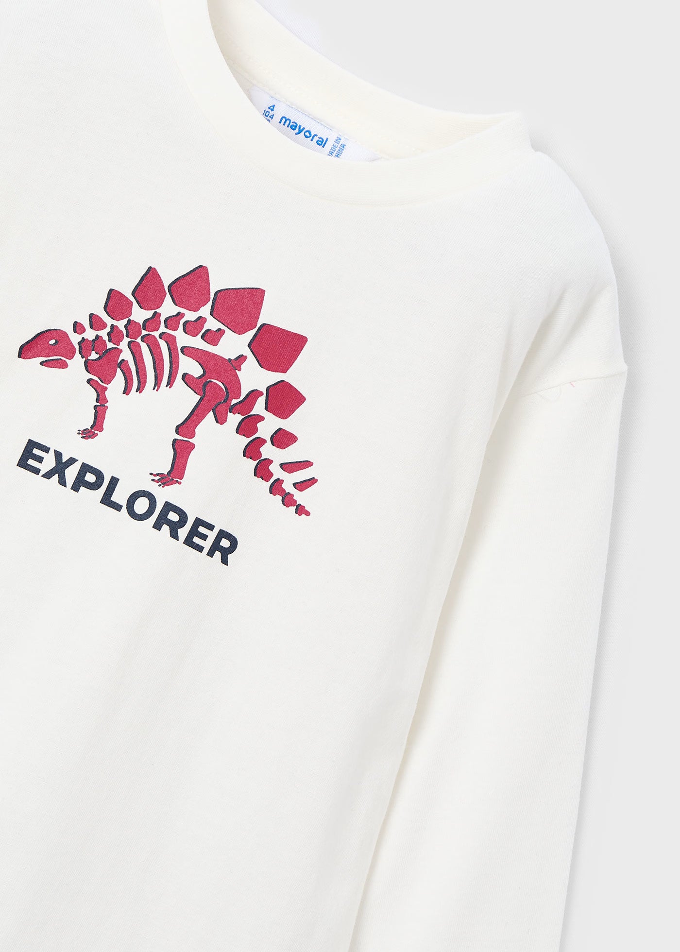 Detalle del estampado de un esqueleto de dinosaurio y la palabra "Explorer" en una playera de manga larga, marca Mayoral.