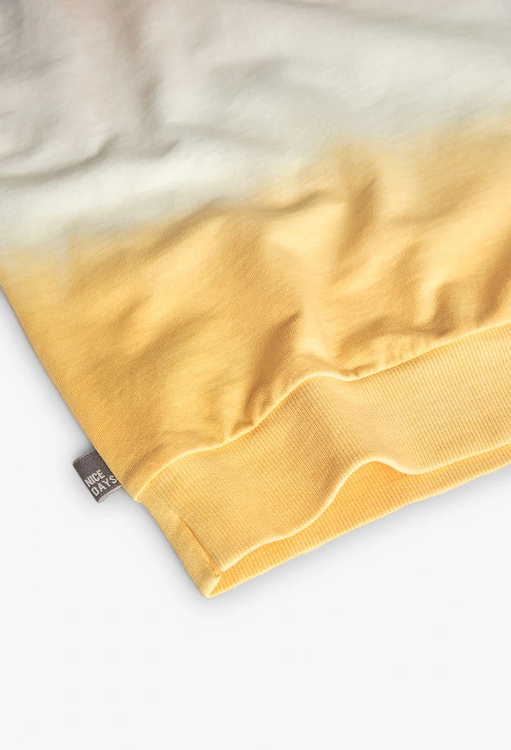 Detalle del dobladillo y etiqueta lateral de la sudadera infantil beige y amarillo de Boboli.