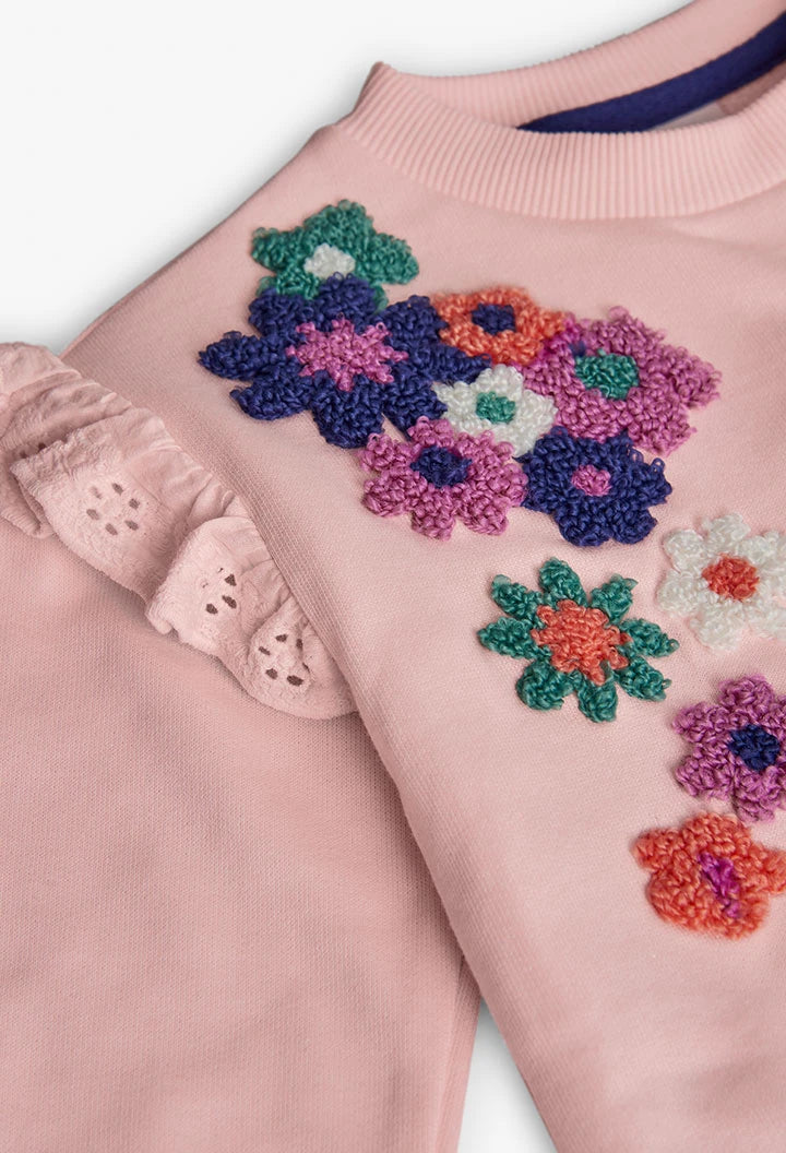 Primer plano de las flores bordadas con textura y el olán con bordado suizo en una sudadera rosa, marca Boboli.