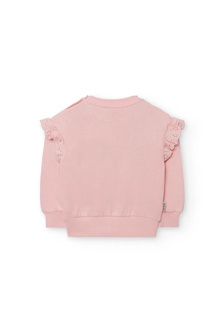 Vista trasera de la sudadera rosa para niña, mostrando los olanes en los hombros y los botones de presión.