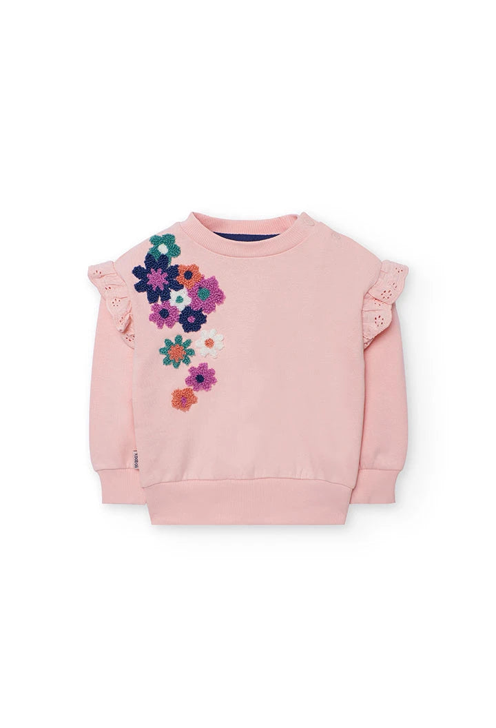 Vista frontal de una sudadera de felpa rosa para niña con flores bordadas en relieve y olanes en los hombros, marca Boboli.