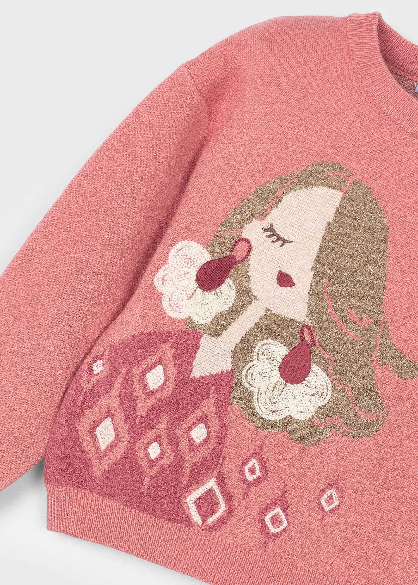 Detalle del dibujo de la muñeca en el suéter, mostrando las diferentes texturas del pelo, los aretes y el vestido.