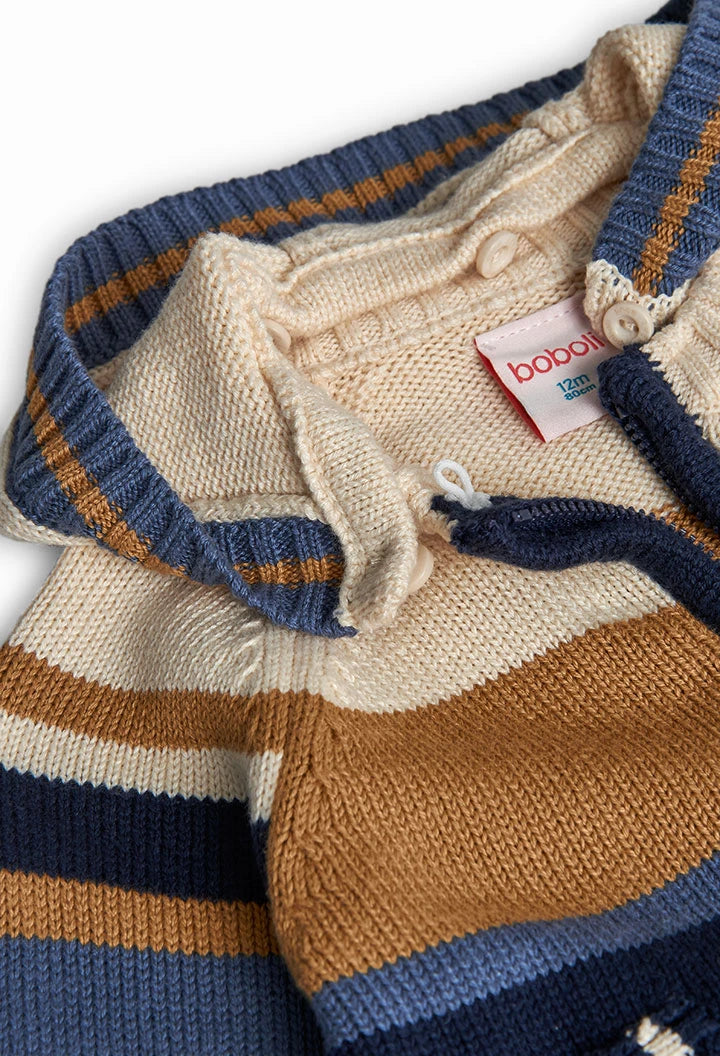 Detalle del cuello tejido, botones y etiqueta de un suéter de punto con capucha, marca Boboli.