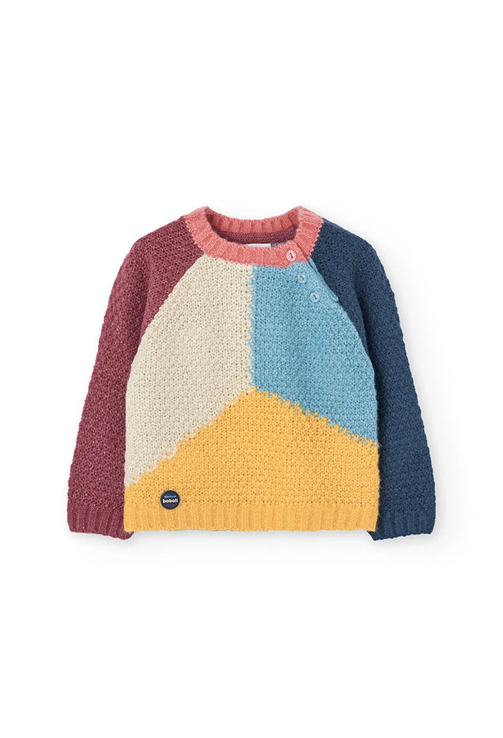 Vista frontal de un suéter de punto para niño con diseño geométrico en bloques de color y botones en el hombro, marca Boboli.