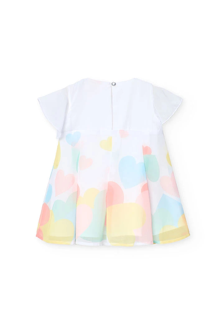 Vista trasera de un vestido blanco con estampado de corazones de colores pastel, manga corta y cierre con botón en la espalda.