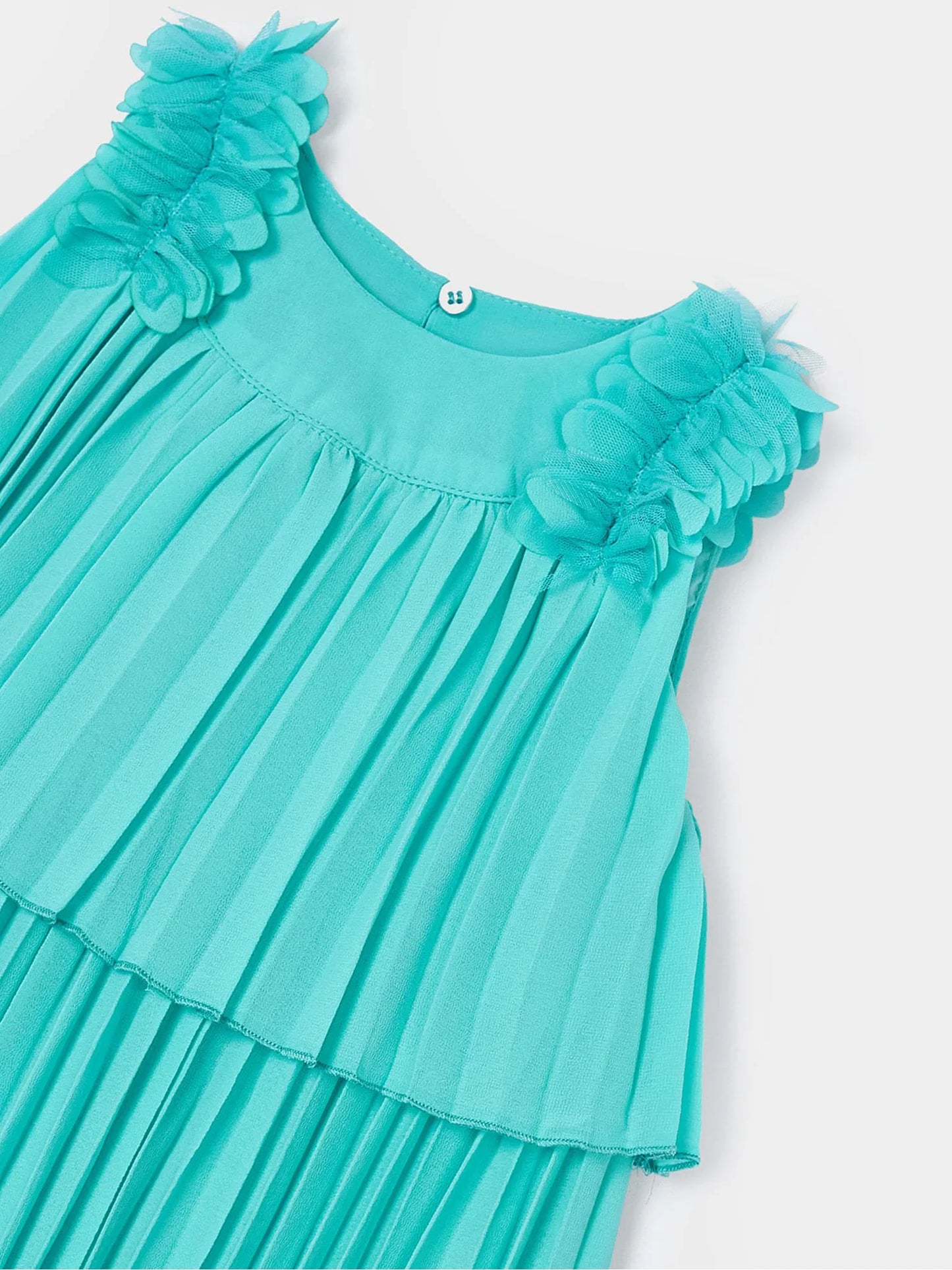 Detalle del vestido plisado en color turquesa con apliques florales en los hombros y cierre de botón en la parte trasera. Diseño elegante y ligero, ideal para ocasiones especiales.