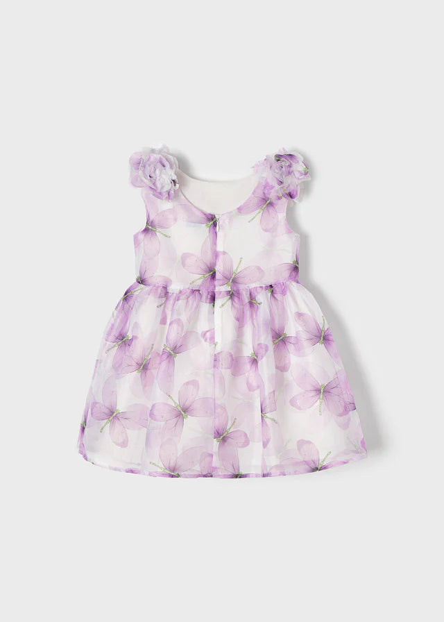 Vista trasera de un vestido infantil con estampado de mariposas en tonos lila y flores decorativas en los hombros, ideal para ocasiones especiales y eventos formales.