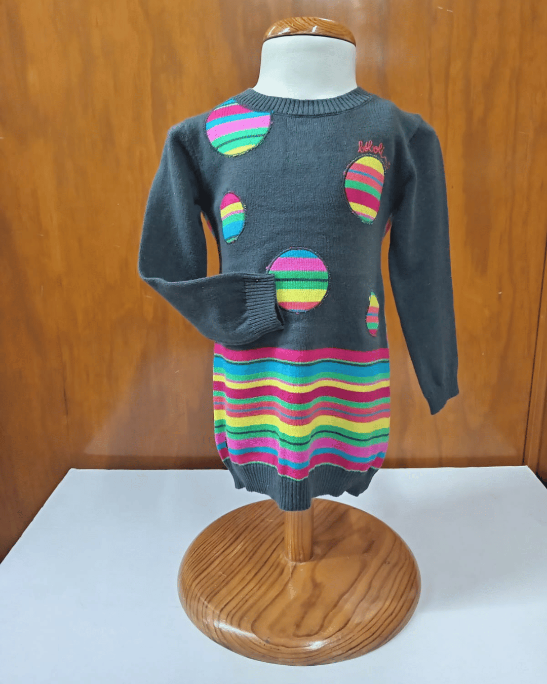 Vestido Boboli para niña en maniquí con diseño de puntos y líneas multicolor sobre fondo gris oscuro