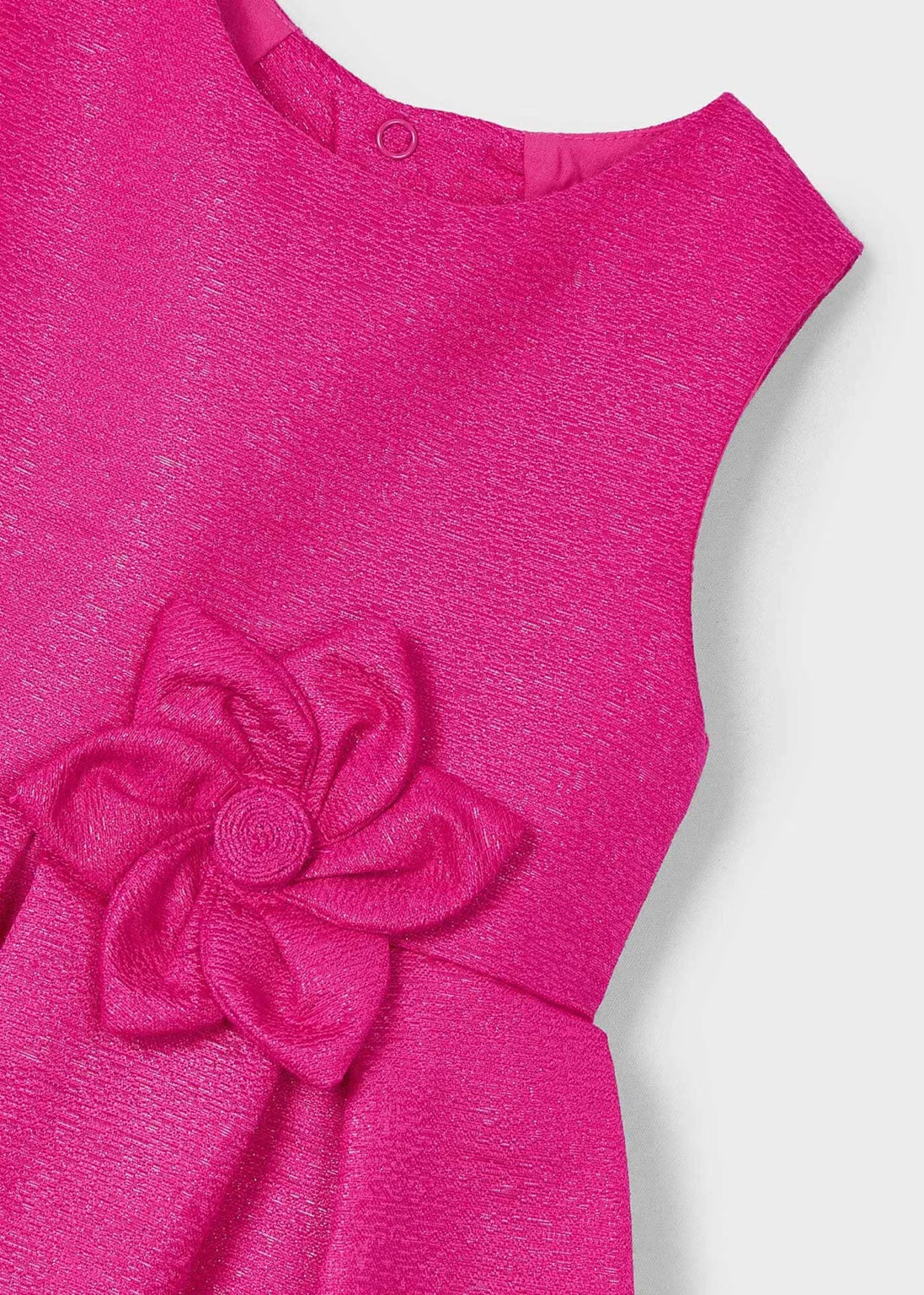 Detalle del tejido y diseño del vestido magenta fiusha de Mayoral, con pliegues delicados y acabado brillante.