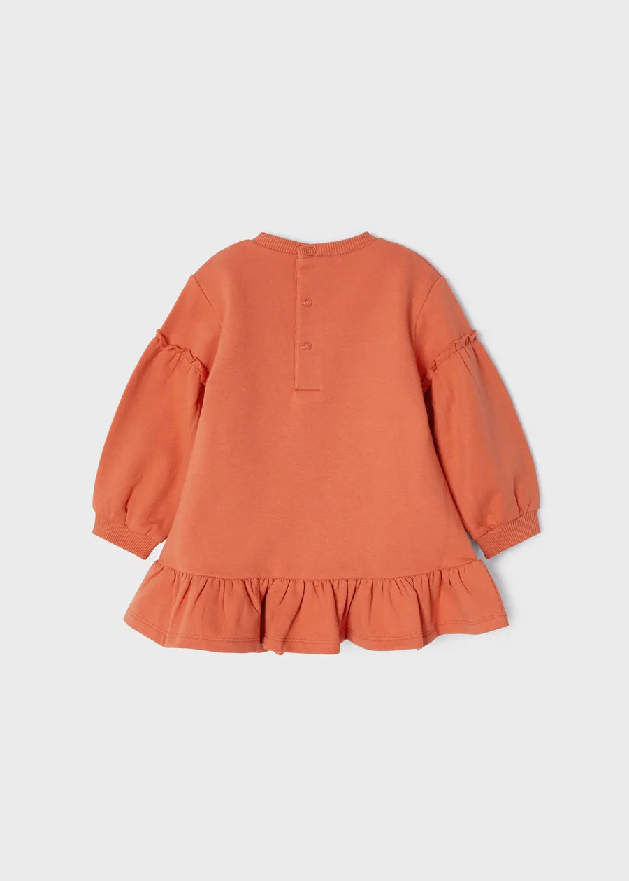 Vista trasera del vestido naranja para niña con botones a presión en la espalda y falda con holán