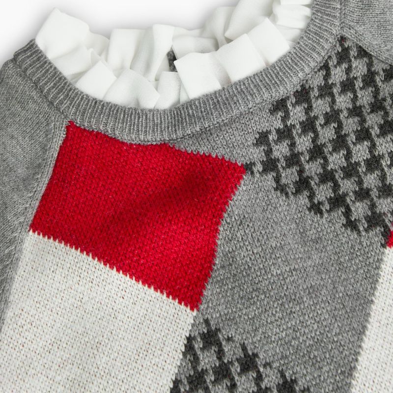 Detalle superior del vestido Boboli con cuello volante blanco y diseño de rombos rojos, blancos y gris con textura de pata de gallo.