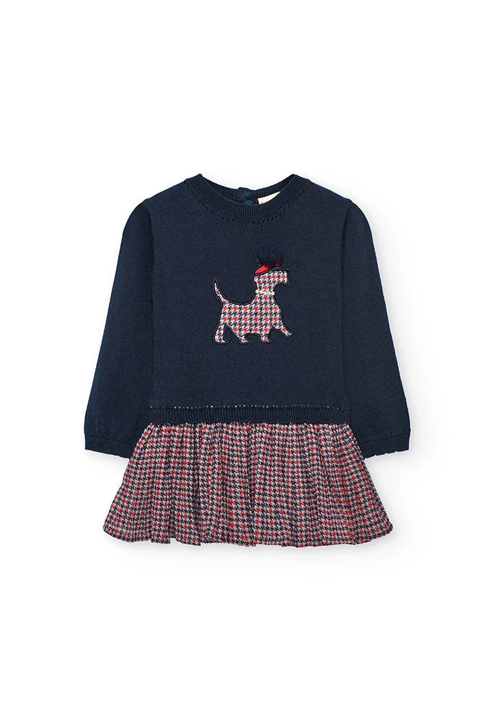 Vista frontal de un vestido para niña con cuerpo de punto azul marino y falda plisada con estampado de pata de gallo, marca Boboli.