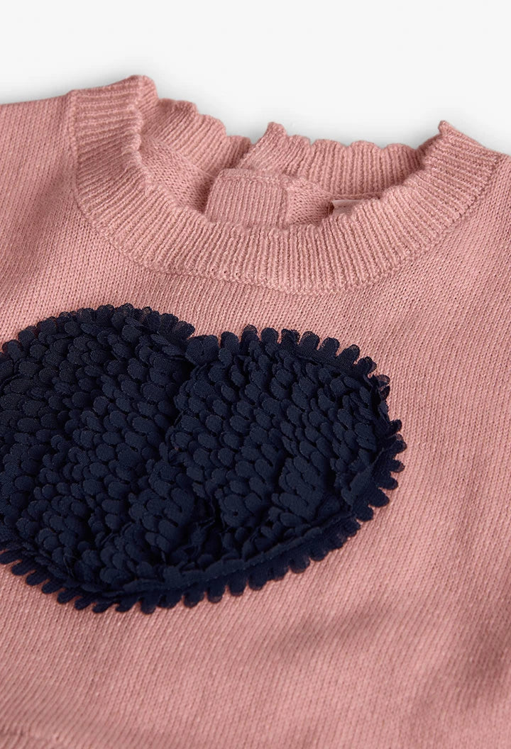 Detalle del aplique de corazón azul marino con textura 3D sobre un suéter de punto rosa, marca Boboli.