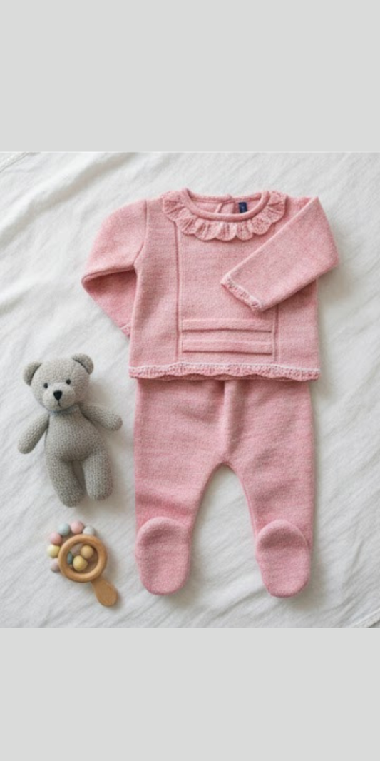 Un conjunto de dos piezas de ropa de bebé en punto rosa pastel, que incluye un suéter con cuello de volantes y un pantalón con pies cubiertos.