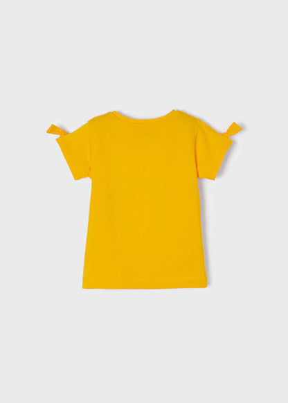 Vista trasera de blusa infantil en color amarillo con mangas cortas y detalles de lazos, confeccionada en algodón para mayor comodidad.