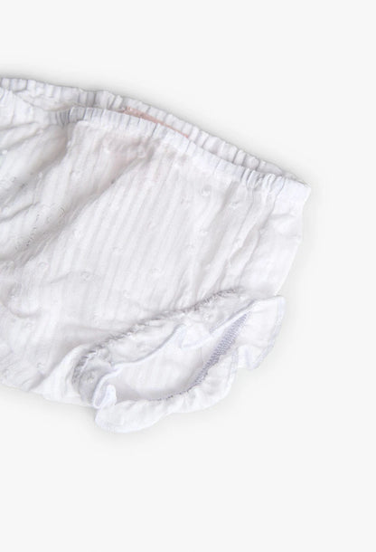 Primer plano del calzón blanco para bebé, resaltando la textura de la tela y los delicados volantes.