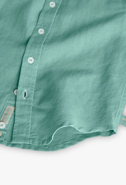Detalle de la parte inferior de la camisa de lino verde de Boboli, resaltando su tela transpirable y etiqueta de calidad. Prenda versátil para ocasiones especiales.