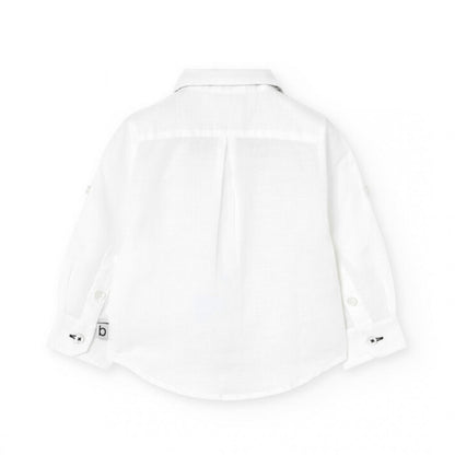 Vista trasera de camisa blanca de manga larga para niño, con detalles elegantes y costuras finas.