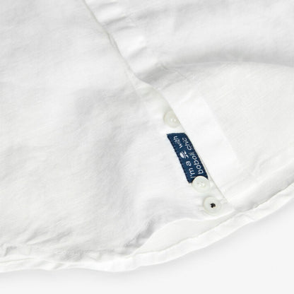 Detalle del dobladillo y etiqueta en la parte inferior de la camisa blanca de Boboli.