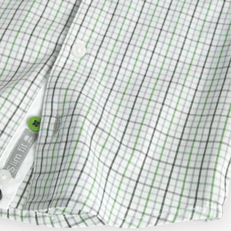 Detalle inferior de la camisa de popelina con botón verde y etiqueta slim fit