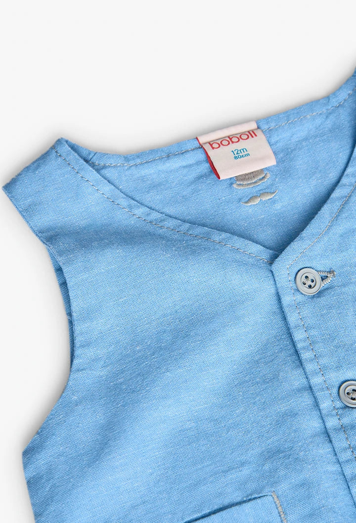 Detalle de botones y escote en V del chaleco de lino azul para niño de la marca Boboli.